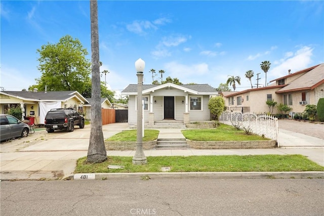 bungalow featuring fence and driveway