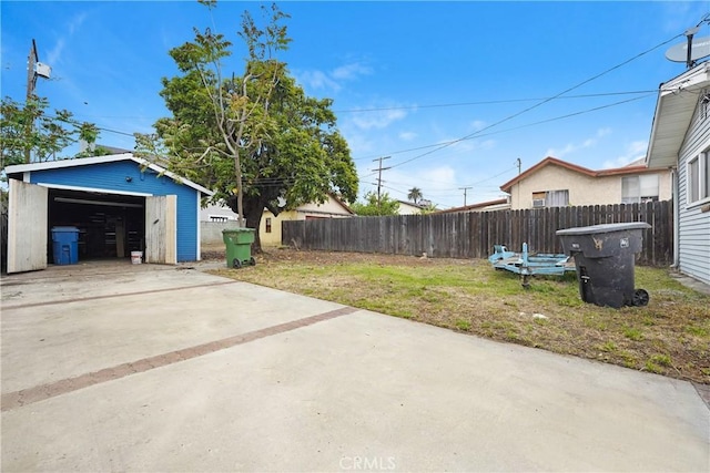 exterior space with fence, an outdoor structure, and a garage