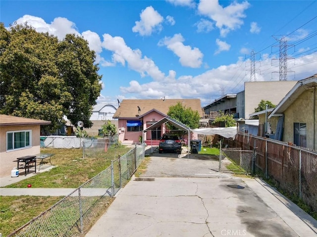 bungalow-style home with fence, a carport, concrete driveway, and a front yard