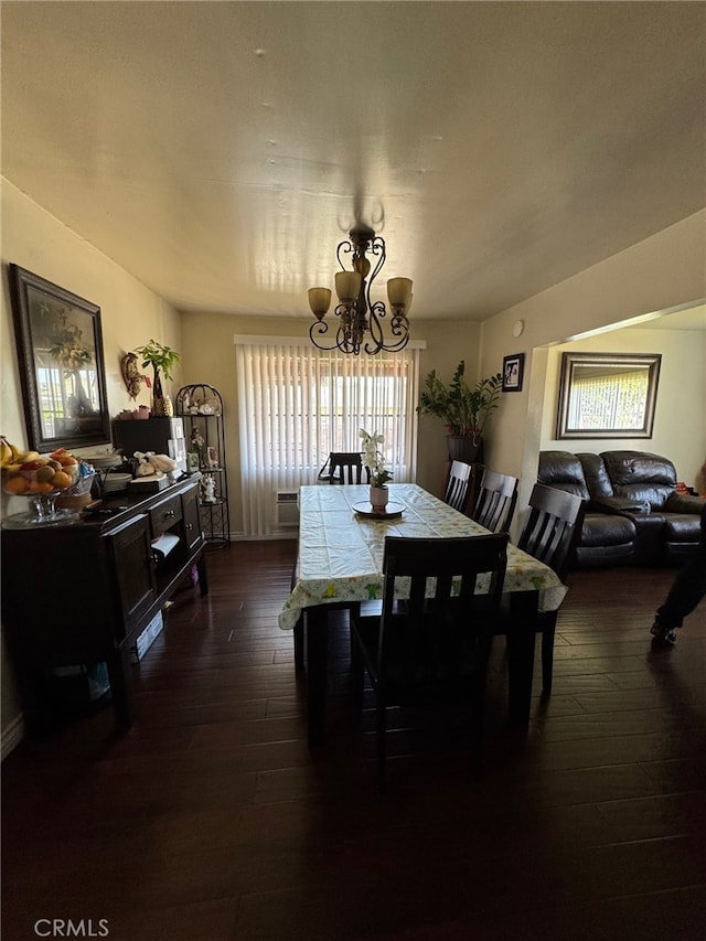 dining room with dark wood-type flooring and a notable chandelier