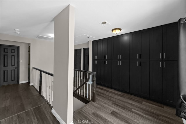 15064 Marcolesco St, Lake Elsinore, CA 92530 - corridor featuring baseboards, visible vents, dark wood-type flooring, and an upstairs landing