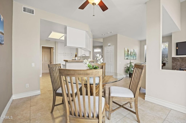 dining area featuring baseboards, a ceiling fan, light tile patterned flooring, and visible vents