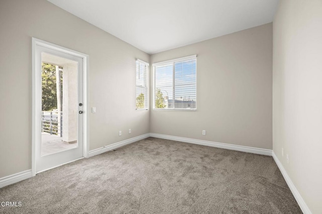 unfurnished room featuring carpet floors and baseboards