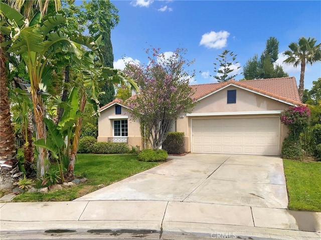 ranch-style house with a garage, a front yard, stucco siding, concrete driveway, and a tile roof