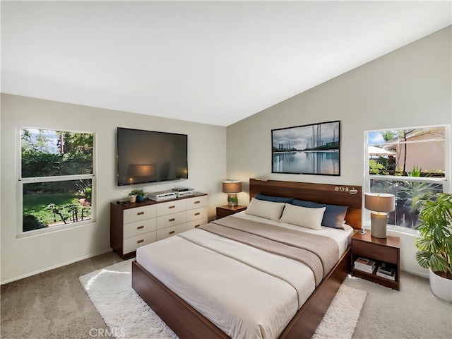 bedroom featuring baseboards, vaulted ceiling, light carpet, and multiple windows