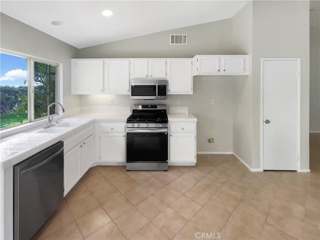 103 Buckthorn Way, Corona, CA 92881 - kitchen featuring stainless steel appliances, tile counters, lofted ceiling, white cabinets, and light tile patterned floors