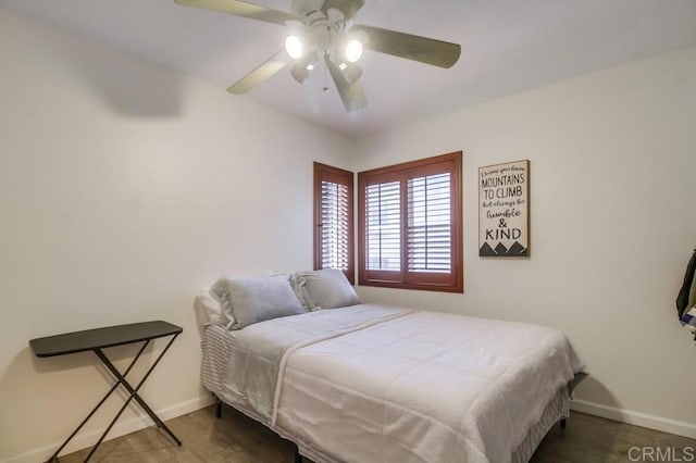 bedroom featuring baseboards, a ceiling fan, and wood finished floors