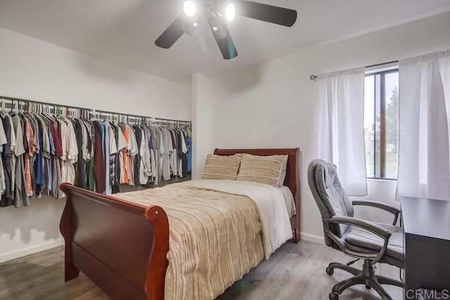 bedroom with baseboards, ceiling fan, and wood finished floors