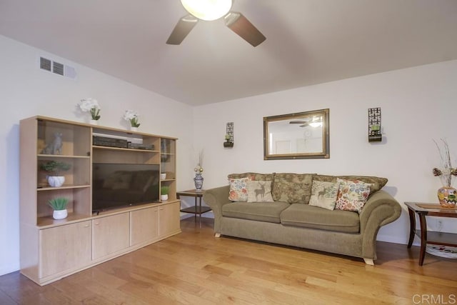living area featuring light wood-style floors, ceiling fan, and visible vents