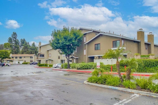 view of property with uncovered parking and a residential view
