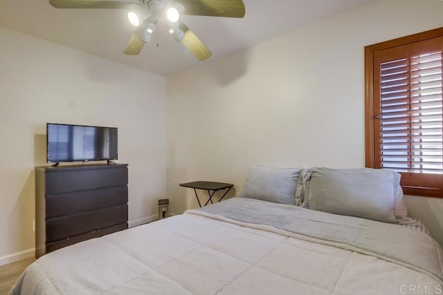 bedroom with a ceiling fan and baseboards
