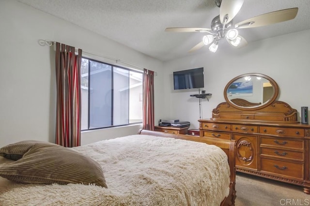 carpeted bedroom featuring a ceiling fan and a textured ceiling
