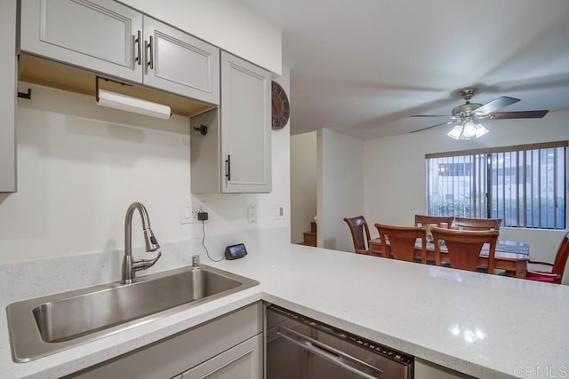 kitchen featuring stainless steel dishwasher, a peninsula, ceiling fan, and a sink