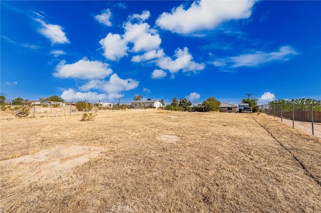 view of yard with fence and a rural view