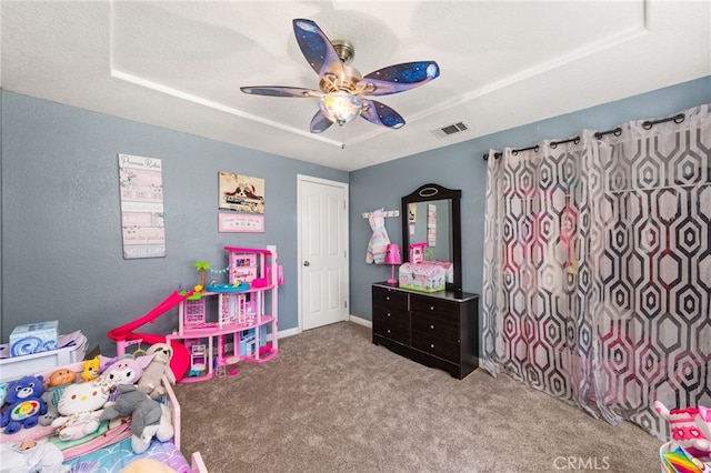 rec room featuring a raised ceiling, ceiling fan, carpet flooring, and visible vents
