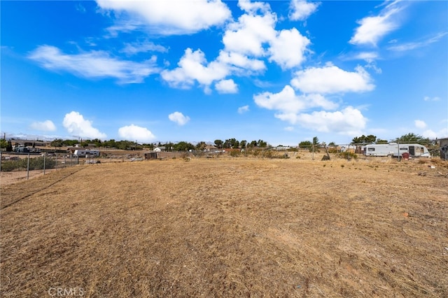 view of yard featuring fence and a rural view