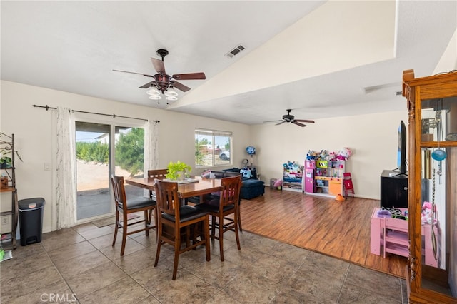 dining space featuring vaulted ceiling, a ceiling fan, and visible vents