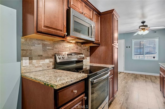 1130 E 1st St Unit 205, Long Beach, CA 90802 - kitchen with light stone countertops, appliances with stainless steel finishes, light wood finished floors, a ceiling fan, and tasteful backsplash
