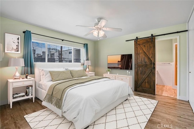 1130 E 1st St Unit 205, Long Beach, CA 90802 - bedroom with a barn door, ceiling fan, and wood finished floors