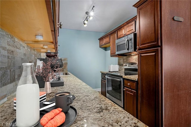 1130 E 1st St Unit 205, Long Beach, CA 90802 - kitchen with appliances with stainless steel finishes, decorative backsplash, light stone countertops, and rail lighting