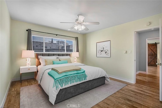 1130 E 1st St Unit 205, Long Beach, CA 90802 - bedroom featuring baseboards, a barn door, ceiling fan, and wood finished floors