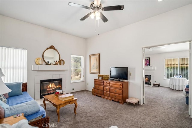 living area with carpet floors, a fireplace, and a ceiling fan