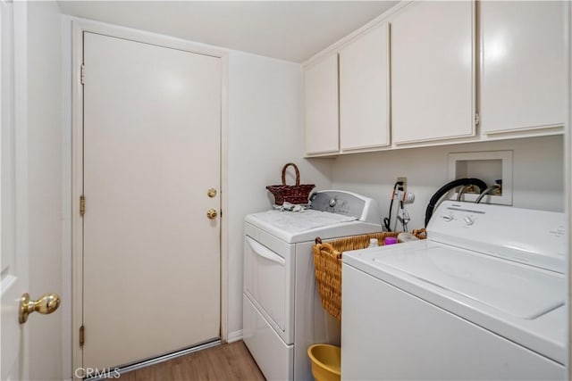 laundry area with light wood finished floors, cabinet space, and washer and clothes dryer