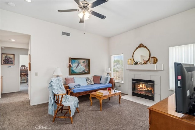 carpeted living room featuring a tiled fireplace, ceiling fan, recessed lighting, and visible vents