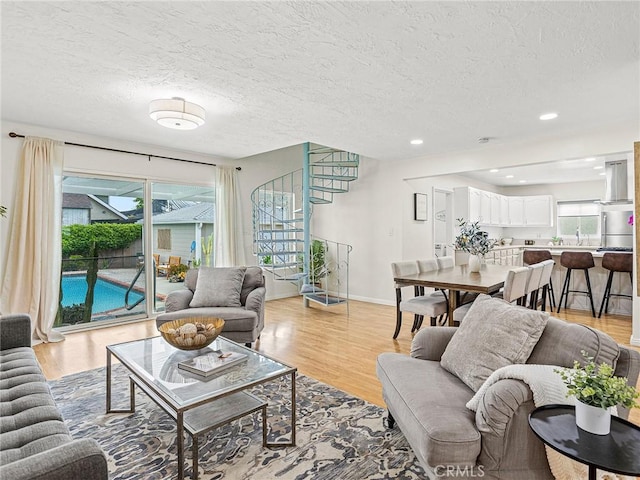 1234 N Pass Ave, Burbank, CA 91505 - living room with light wood-type flooring, a textured ceiling, baseboards, and stairway