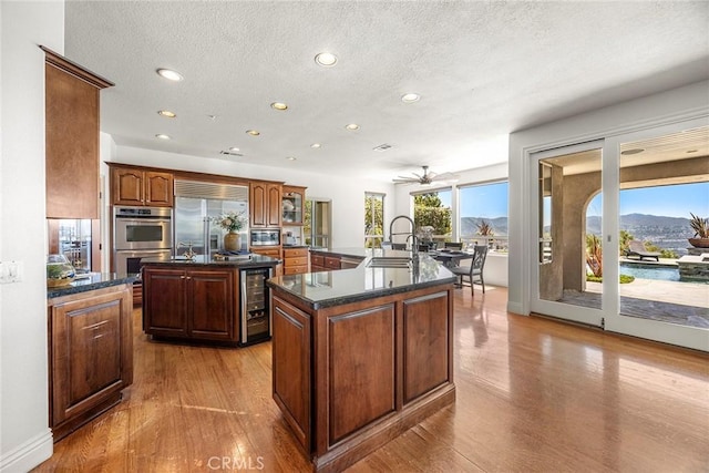 26930 Ironstone, Yorba Linda, CA 92887 - kitchen featuring a kitchen island with sink, appliances with stainless steel finishes, a sink, wine cooler, and recessed lighting