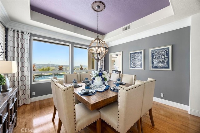 26930 Ironstone, Yorba Linda, CA 92887 - dining room with a tray ceiling, baseboards, a chandelier, light wood-style floors, and a textured ceiling