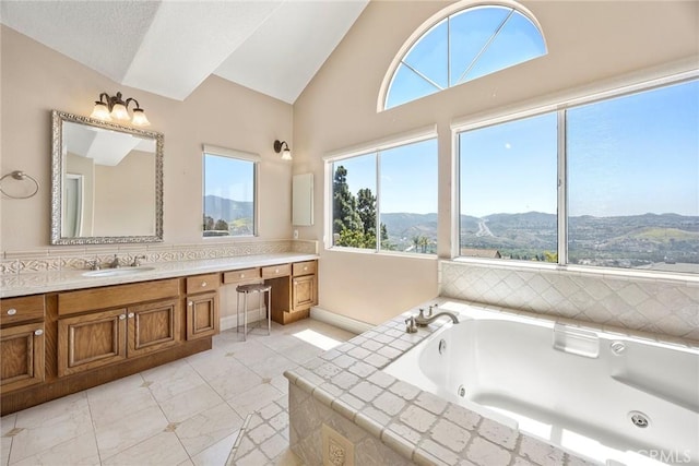 26930 Ironstone, Yorba Linda, CA 92887 - bathroom featuring vaulted ceiling, vanity, a tub with jets, a mountain view, and baseboards