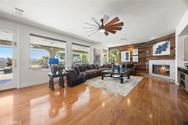 26930 Ironstone, Yorba Linda, CA 92887 - living area with ceiling fan, wood finished floors, a fireplace, wood walls, and a textured ceiling