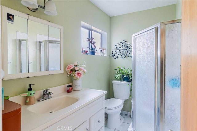 full bathroom featuring vanity, tile patterned flooring, a stall shower, and toilet