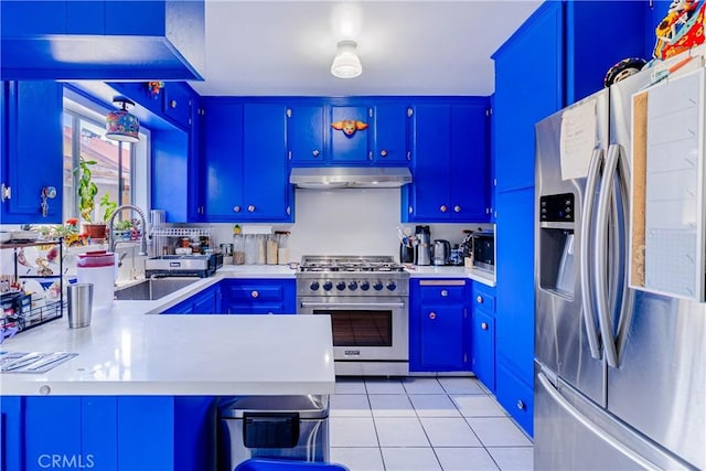 kitchen featuring light countertops, under cabinet range hood, a sink, appliances with stainless steel finishes, and light tile patterned floors