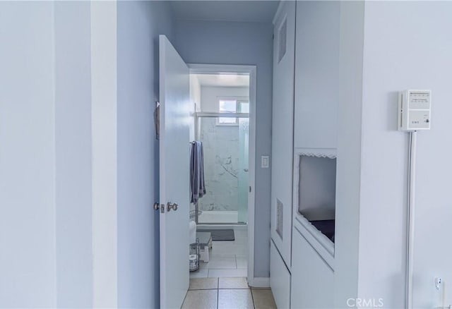corridor with baseboards and light tile patterned flooring