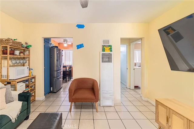 sitting room with a heating unit, visible vents, plenty of natural light, and light tile patterned floors