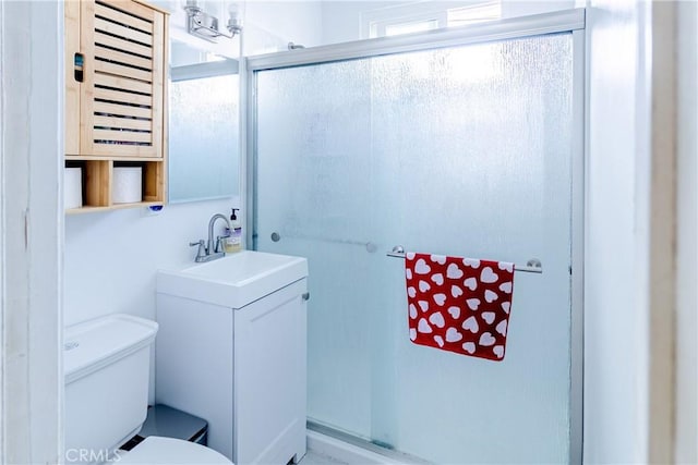 bathroom with vanity, a shower with shower door, and toilet