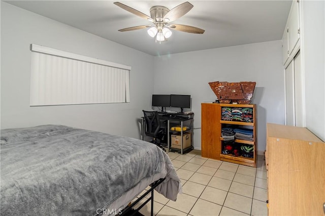 bedroom featuring light tile patterned floors, ceiling fan, and a closet