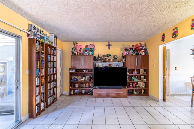 living room with baseboards, a textured ceiling, and light tile patterned floors