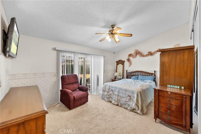bedroom with carpet flooring, a textured ceiling, a ceiling fan, access to exterior, and a wainscoted wall