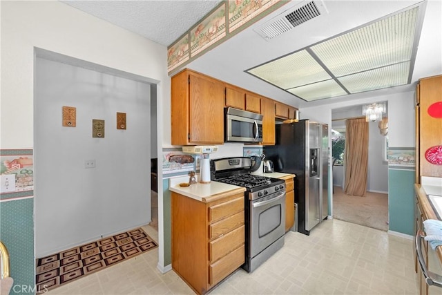 kitchen featuring stainless steel appliances, light countertops, baseboards, and brown cabinetry