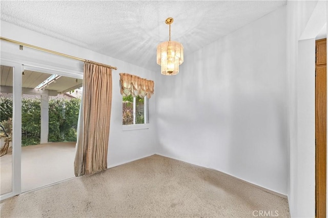 unfurnished room featuring a chandelier and speckle patterned floor