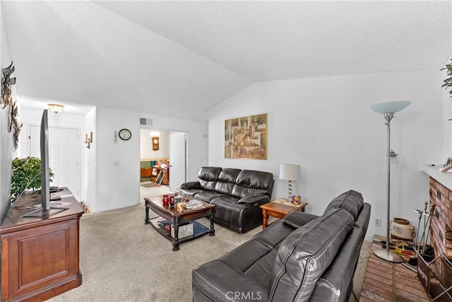 carpeted living area with vaulted ceiling and a textured ceiling