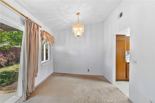 empty room featuring a chandelier and light carpet