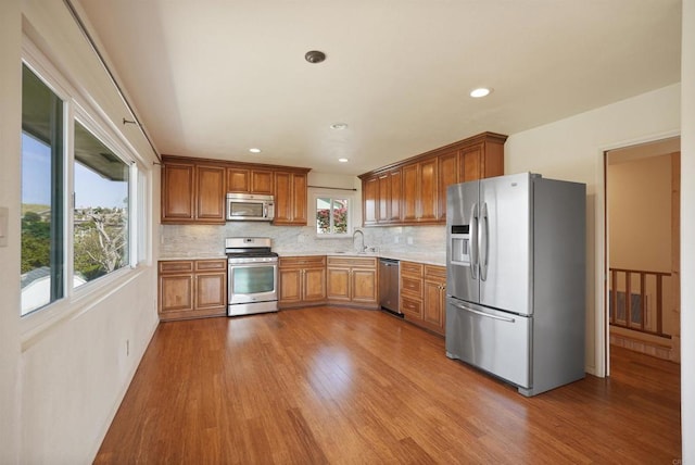 5884 Redondo Dr, Bonsall, CA 92003 - kitchen with stainless steel appliances, a sink, light countertops, wood finished floors, and recessed lighting