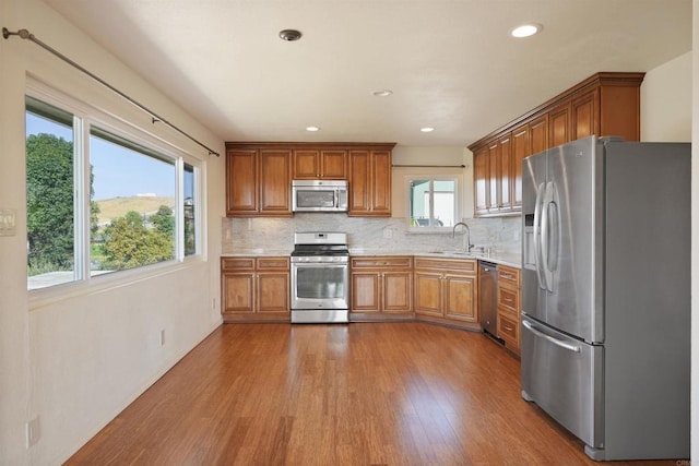 5884 Redondo Dr, Bonsall, CA 92003 - kitchen featuring appliances with stainless steel finishes, a sink, brown cabinets, light countertops, and recessed lighting