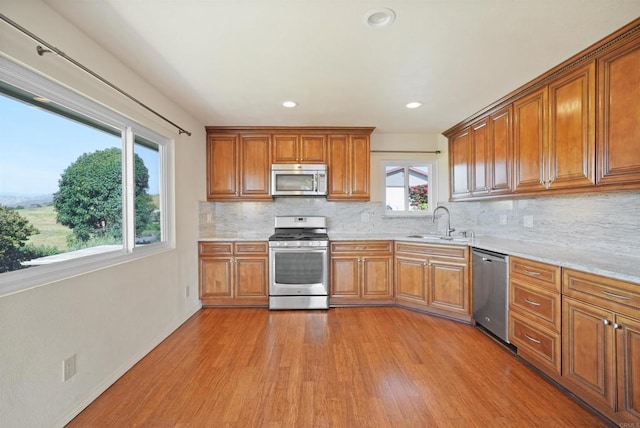 5884 Redondo Dr, Bonsall, CA 92003 - kitchen with stainless steel appliances, a sink, light wood finished floors, brown cabinetry, and recessed lighting