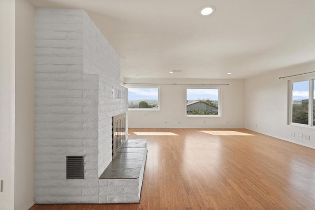 5884 Redondo Dr, Bonsall, CA 92003 - unfurnished living room with a brick fireplace, wood finished floors, recessed lighting, and baseboards