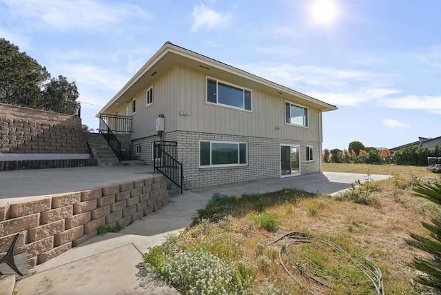 5884 Redondo Dr, Bonsall, CA 92003 - back of property featuring stairs, a patio, and brick siding
